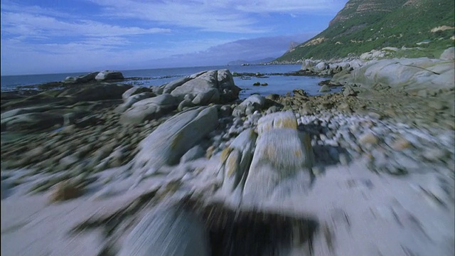 航拍越过多岩石的海岸线，飞向大海视频素材