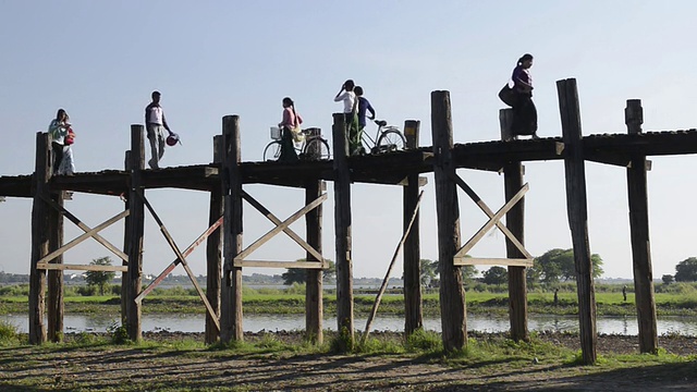 图为当地人走过Taungthaman湖上的U Bein柚木桥。/ Amarapura，曼德勒，曼德勒省，缅甸视频素材