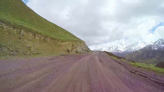 POV汽车行驶在积雪和蜿蜒的山路上/中国青海。视频素材