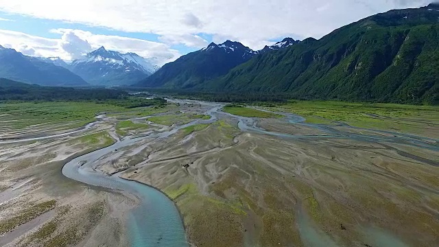 鸟瞰图向前飞过编织的河口朝向山脉视频素材