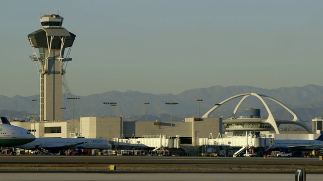 伊娃航空(Eva Air)的波音777型出租车进入洛杉矶国际机场(LAX)控制塔和主题餐厅的背景框架视频素材