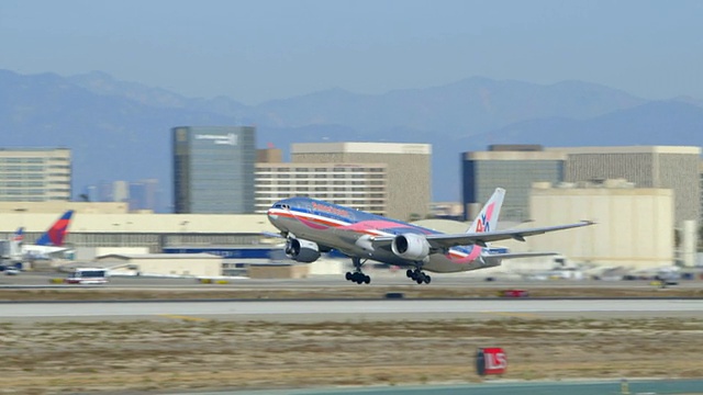 美国航空公司(American Airlines)波音777带乳腺癌意识外部图形从洛杉矶国际机场起飞视频素材