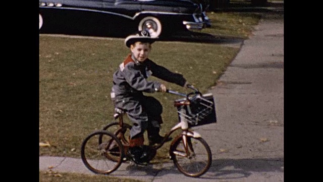 1957年穿着治安官服装骑着三轮车的男孩视频素材