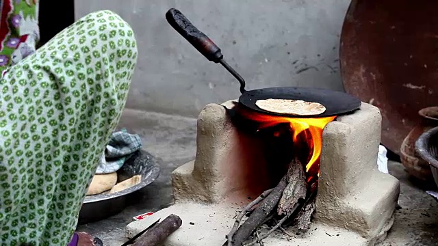 妇女在泥炉上做饭视频素材