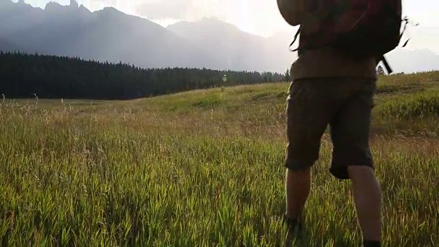 情侣徒步穿越高山草地，用智能手机拍照视频素材