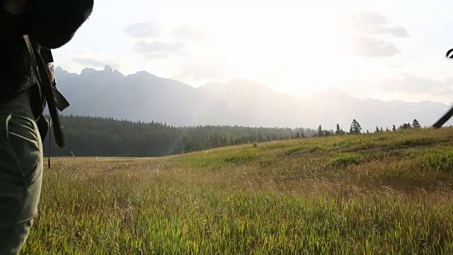 情侣徒步穿越高山草地，用智能手机拍照视频素材