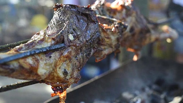 用烤肉叉烤一大块羊肉。视频素材