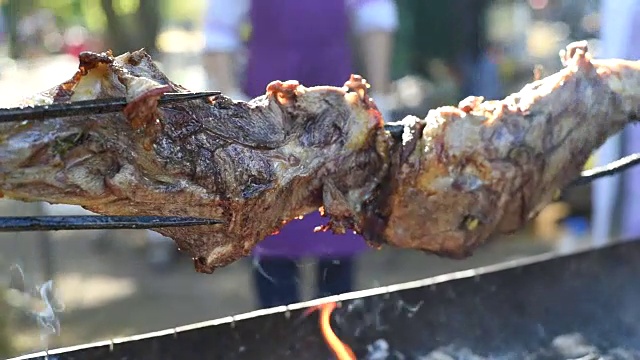 用烤肉叉烤一大块羊肉。视频素材