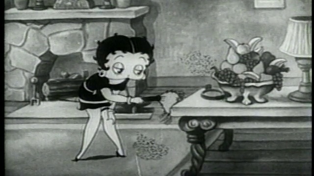 1937年出品的动画《贝蒂娃娃》(Betty Boop)给桌子掸灰尘，还从一碗水果上摘了一串葡萄视频素材