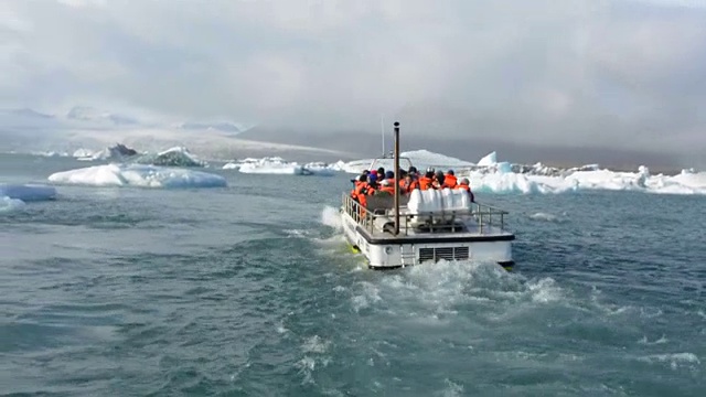 冰岛东南部Vatnajokull国家公园边缘的Jokulsarlon冰川和泻湖上的冰山，游船在游弋视频素材