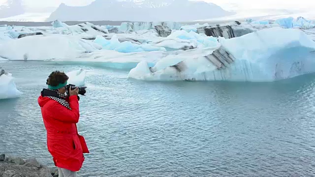 在冰岛东南部的Vatnajokull国家公园边缘，摄影师与Jokulsarlon冰川和泻湖上的冰山合影视频素材