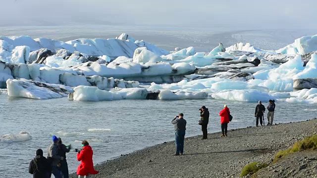 在冰岛东南部的Vatnajokull国家公园边缘，摄影师与Jokulsarlon冰川和泻湖上的冰山合影视频素材