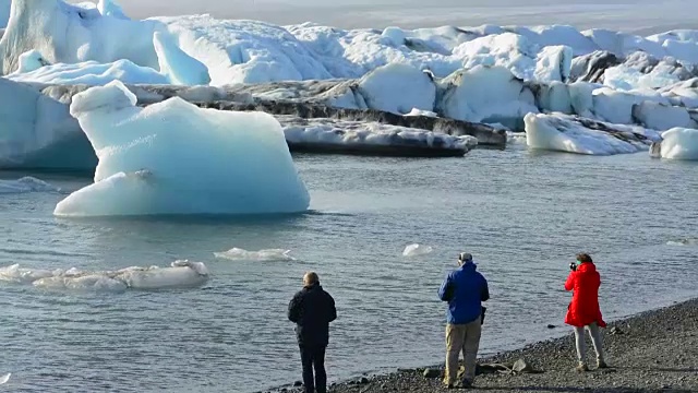 在冰岛东南部的Vatnajokull国家公园边缘，摄影师与Jokulsarlon冰川和泻湖上的冰山合影视频素材