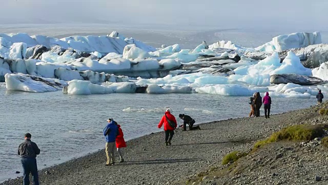 在冰岛东南部的Vatnajokull国家公园边缘，摄影师与Jokulsarlon冰川和泻湖上的冰山合影视频素材