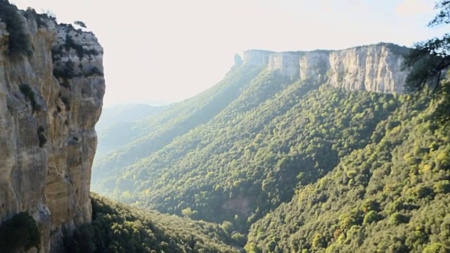 徒步旅行者坐在悬崖上，从私人视角欣赏山谷景色。视频素材