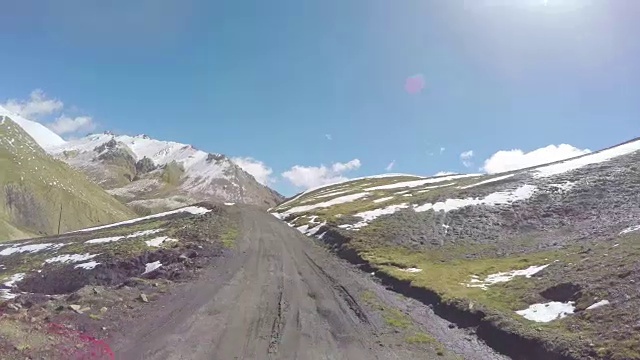 POV汽车行驶在积雪和蜿蜒的山路上/中国青海。视频素材