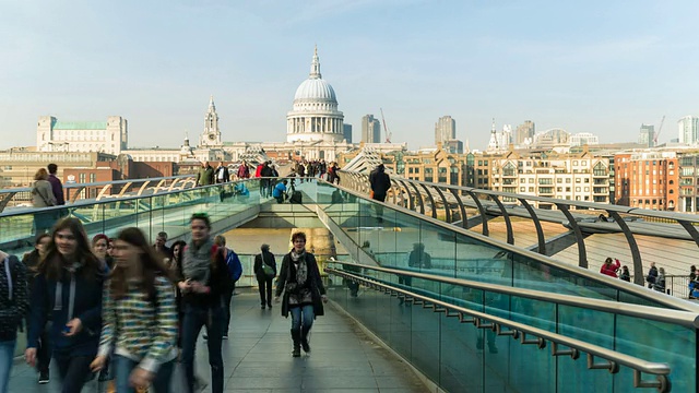 英国伦敦，行人穿过千年桥和圣保罗大教堂视频素材