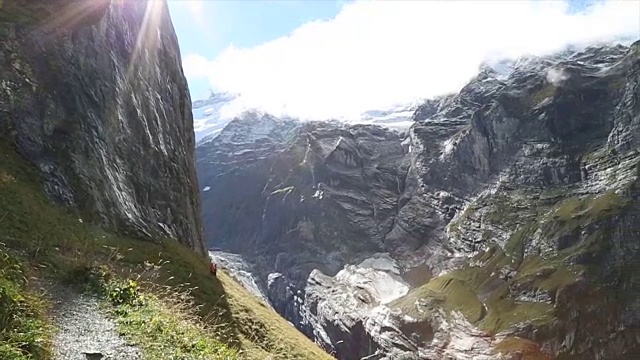 平底锅下到徒步旅行者通过山草地的小路上视频素材