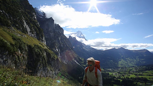 徒步旅行者攀登山间草地的小路视频素材