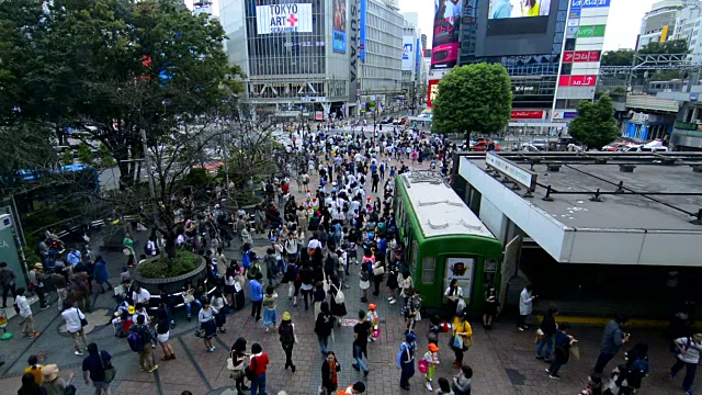 日本东京，熙熙攘攘的涉谷车站地区的Shibuya十字路口，熙熙攘攘的街道和人行道上到处都是当地人视频素材