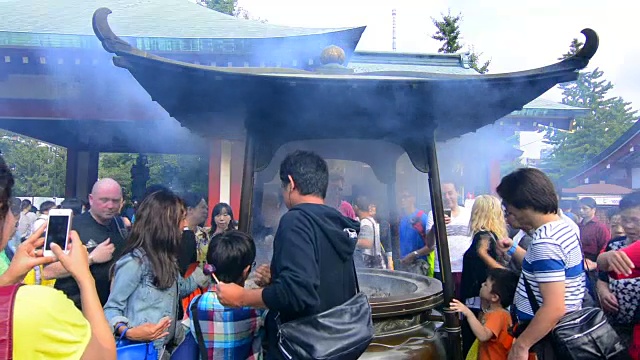 东京，日本浅草寺，人群聚集在东京最古老的寺庙，佛教徒在脸上抹烟祈祷视频素材