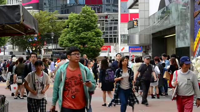 日本东京，熙熙攘攘的涉谷车站地区的Shibuya十字路口，熙熙攘攘的街道和人行道上到处都是当地人视频素材