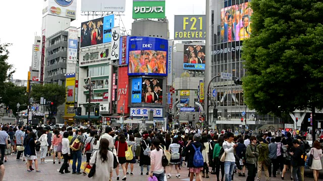 日本东京，熙熙攘攘的涉谷车站地区的Shibuya十字路口，熙熙攘攘的街道和人行道上到处都是当地人视频素材