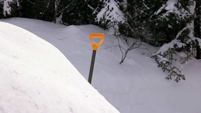 森林里的某个地方，雪地里有一把黄黑相间的铁铲视频素材