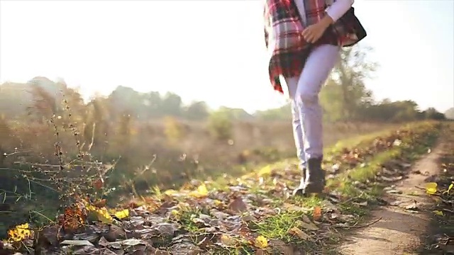 女人走过地上的秋叶视频素材