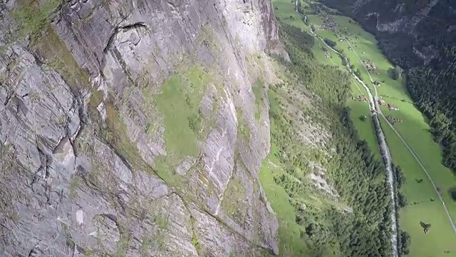 翼服飞行员从悬崖上跳下，在山谷上空翱翔视频素材