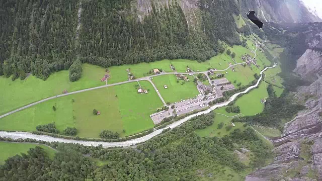 翼服飞行员从悬崖上跳下，在山谷上空翱翔视频素材