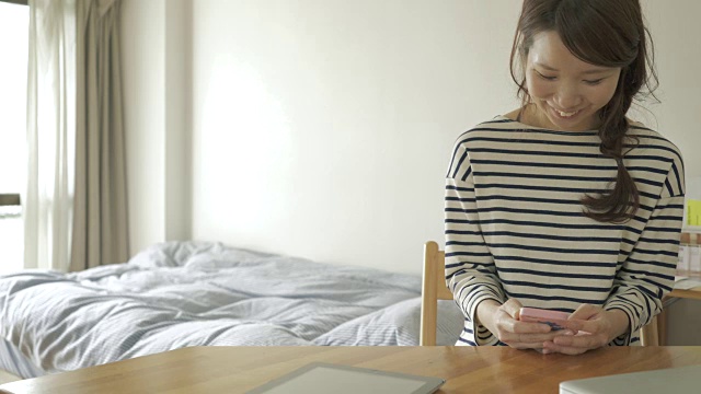 在房间里用智能手机的女人视频素材