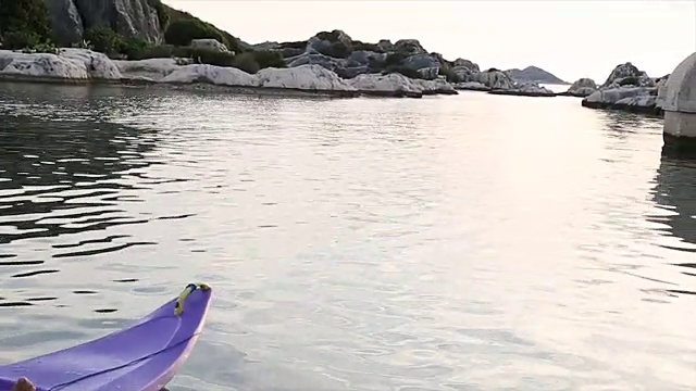 一个成熟的男人划着皮划艇去打捞一具部分沉没的石棺视频素材