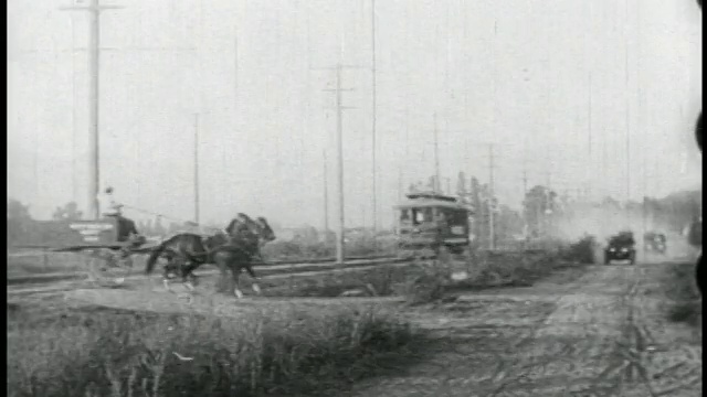 一辆1910年代的车跟在手推车后面撞到马车上视频素材