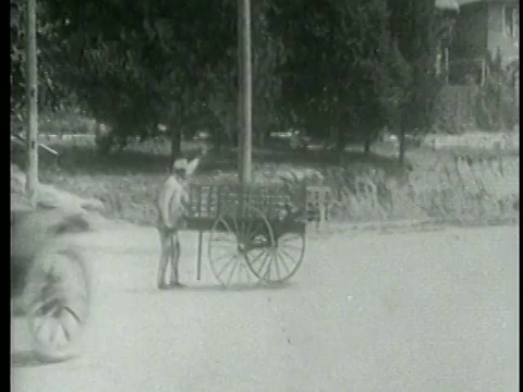 1915年Keystone Kops在车里在空中射击+撞倒推车的人视频素材