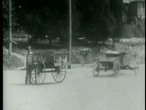 1915年，一名男子和一名女子在街上倒车，撞到一名推着手推车的男子视频素材