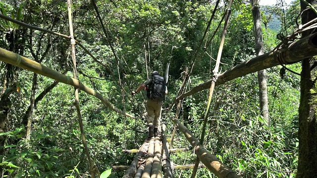 一个徒步旅行者的脚在缅甸丛林的脚桥上的特写视频素材