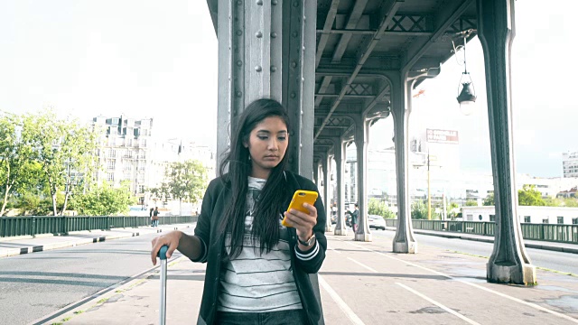 一名女子在街上用智能手机叫出租车视频素材