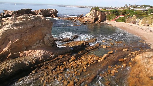 MS AERIAL POV拍摄的海浪撞击海滩和悬崖/新港海滩，加州，美国视频素材