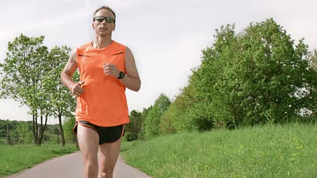 SLO MO TS男性跑步者在阳光下穿过乡村视频素材