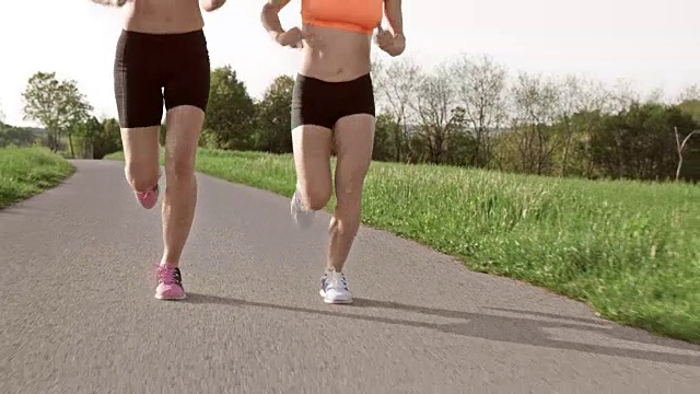 SLO MO TS两个女人跑步时的腿视频素材