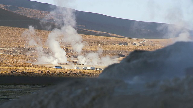 在智利北grande的El Tatio间歇泉/ San Pedro de Atacama的蒸汽喷口之间的旅游车辆视频素材