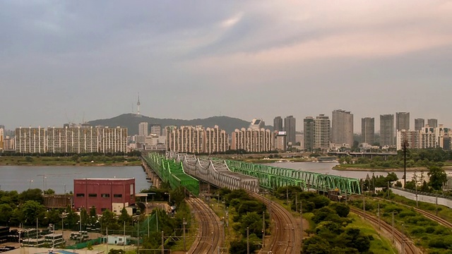 日落时分，火车驶过汉江cheolgyo(铁路桥)的景象/韩国首尔视频素材