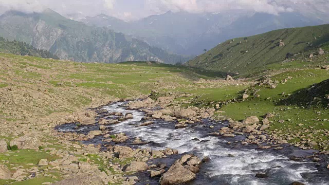 这是一幅从哈穆克山脚下流向克什米尔山谷的河流的时间流逝图，在远处可以看到林木线视频素材