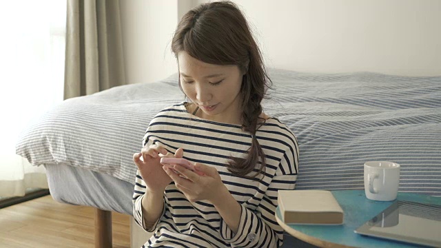 在房间里玩智能手机的女人视频素材