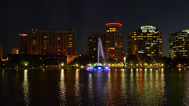 奥兰多佛罗里达湖Eola天际线黄昏夜晚彩色的灯光雕像夜晚暴露与天际线摩天大楼的水在湖与喷泉视频素材