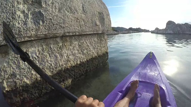 人皮划艇通过平静的大海，在岩石湾视频素材