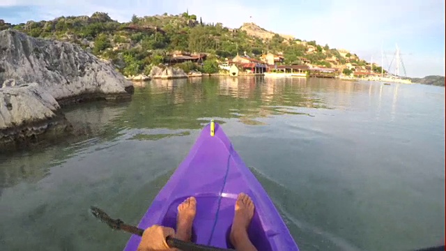 人皮划艇通过平静的大海，在岩石湾视频素材