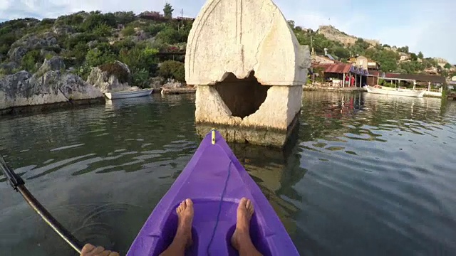 人皮划艇通过平静的大海，在岩石湾视频素材