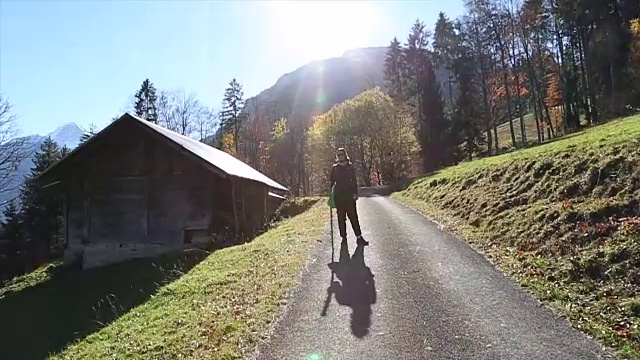 一个年轻人走在高山上的一条路上视频素材